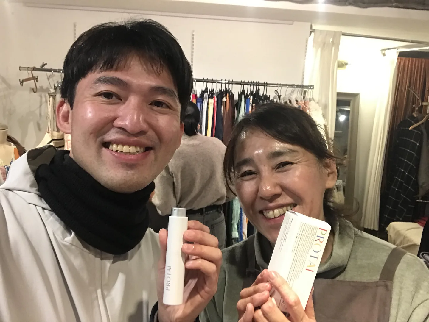 兩人手持 PROTAI 噴霧瓶與外盒